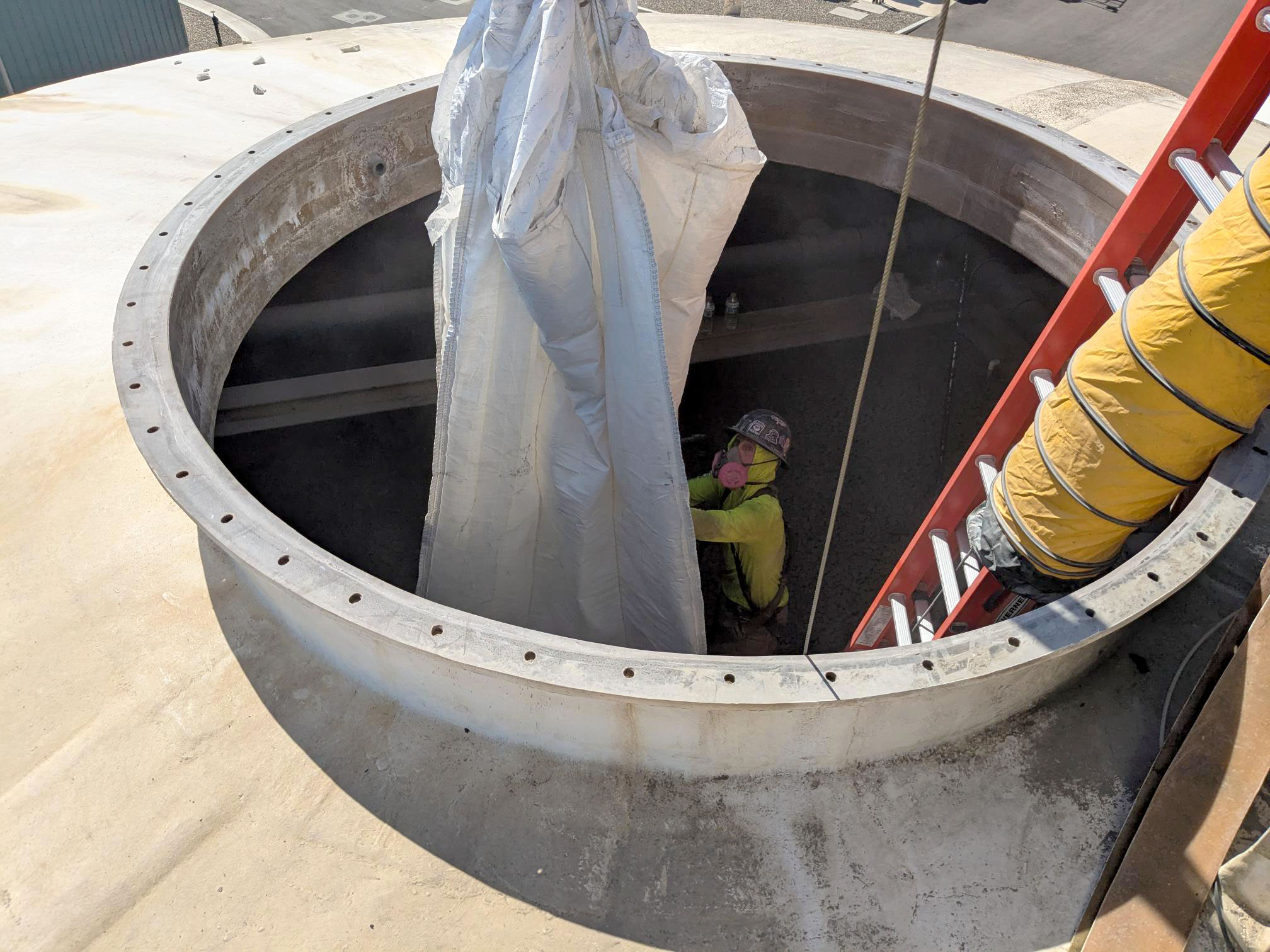 The crane pulls an empty sack through the entryway at the top of the north tower